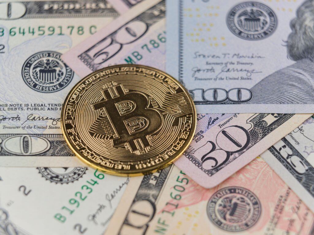 pexels photo 18066309 18066309 Close-up of a Bitcoin coin on US dollar banknotes, symbolizing cryptocurrency and traditional finance.